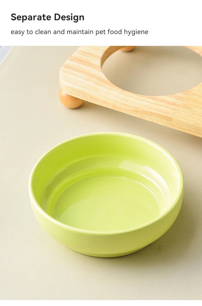 A bright lime green ceramic pet bowl is shown on a light surface, with a wooden stand partially visible.