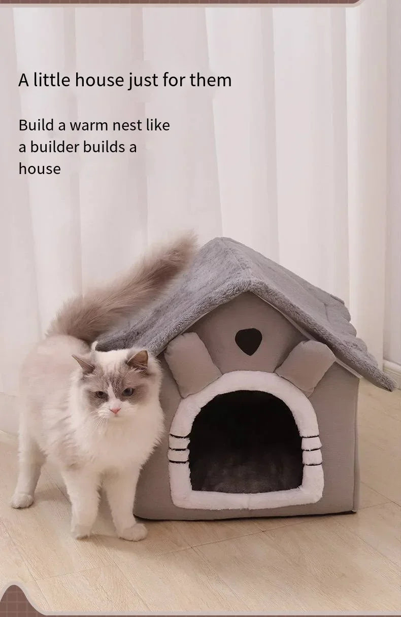 A gray pet house structure with an entrance, featuring a fluffy white cat sitting in front of it.