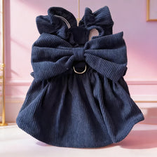 A navy blue vintage corduroy pet dress featuring a large bow and ruffled skirt.
