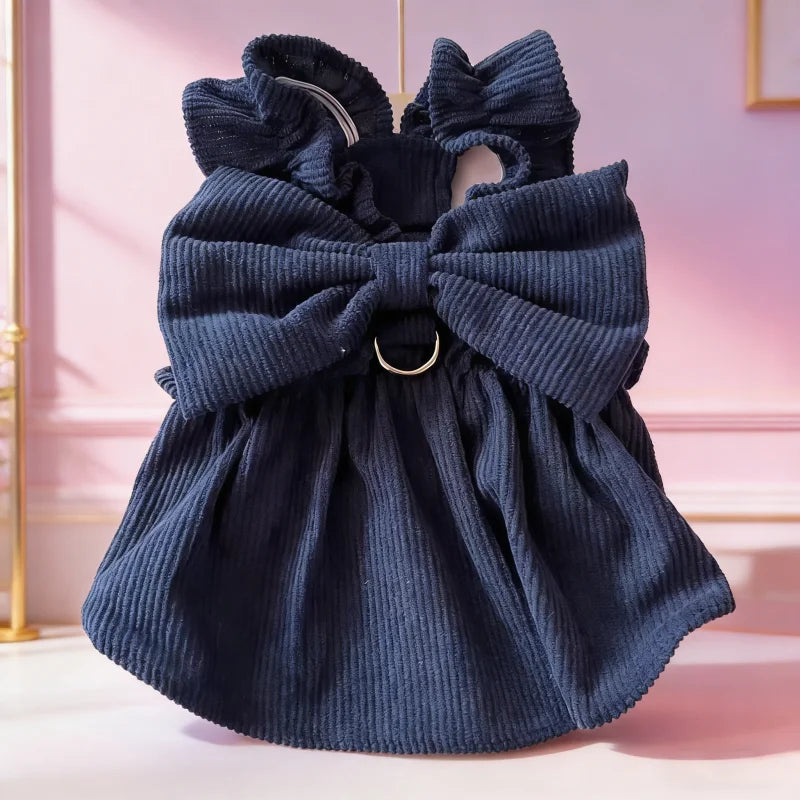 A navy blue vintage corduroy pet dress featuring a large bow and ruffled skirt.
