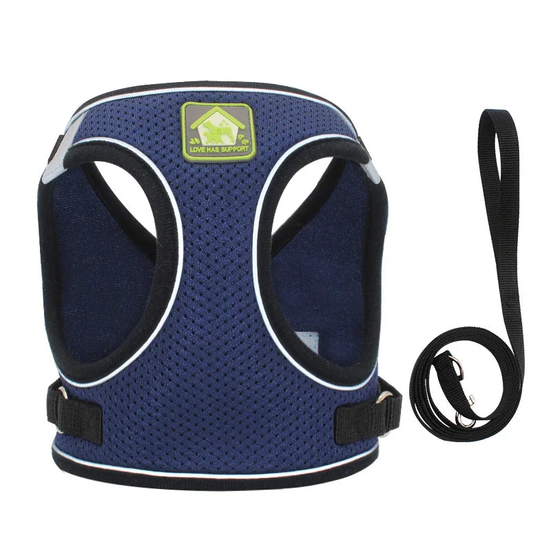 A navy blue mesh dog harness with a yellow tag and black strap is shown against a white background.