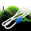 White flexible siphon cleaner tubing with a blue connector lying on green grass.
