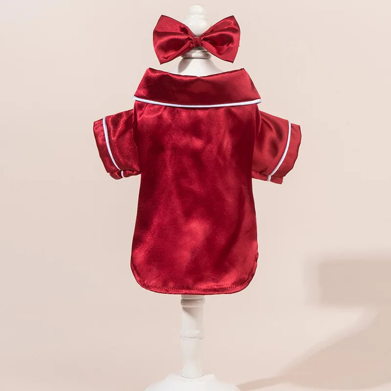 Parte superior de pijama para perro de satén rojo con ribete blanco y diadema con lazo a juego, exhibido en maniquí.