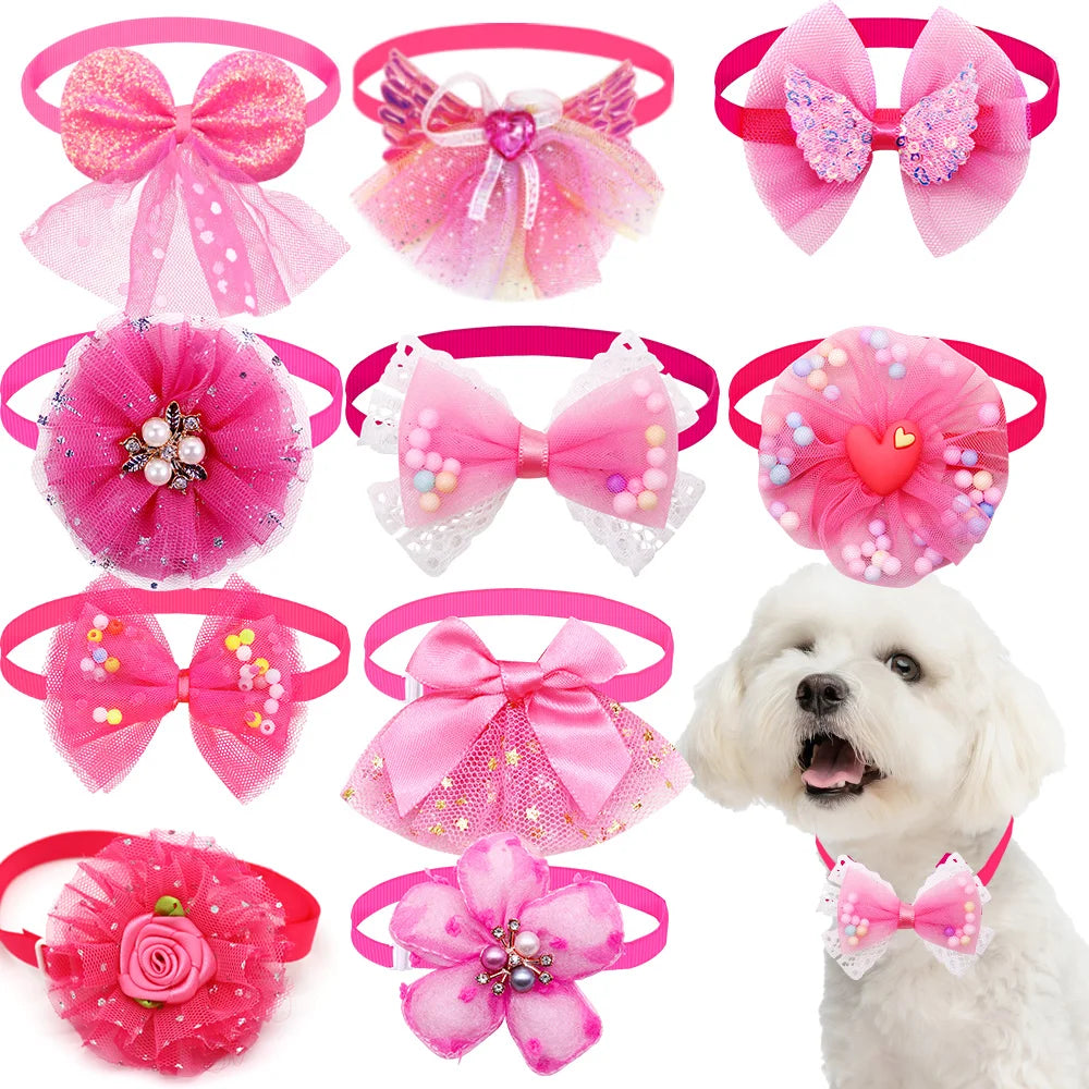 A collection of pink lace bowtie collar accessories for small dogs and cats, including bows and floral shapes.