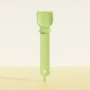 A light green long-handled pet food dispensing spoon with a rounded handle and a tapered end.