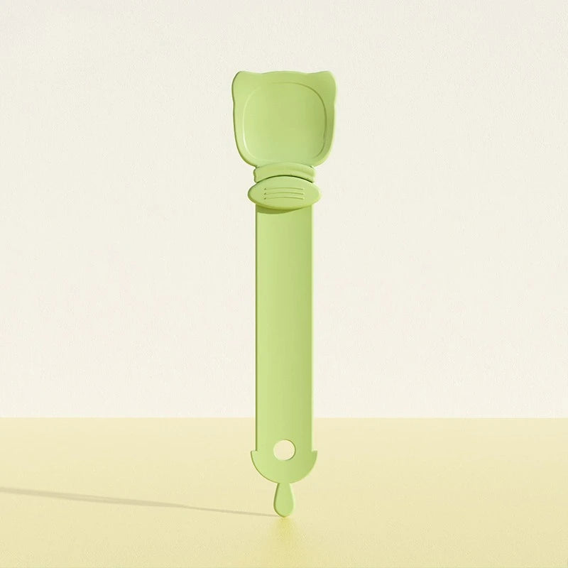 A light green long-handled pet food dispensing spoon with a rounded handle and a tapered end.