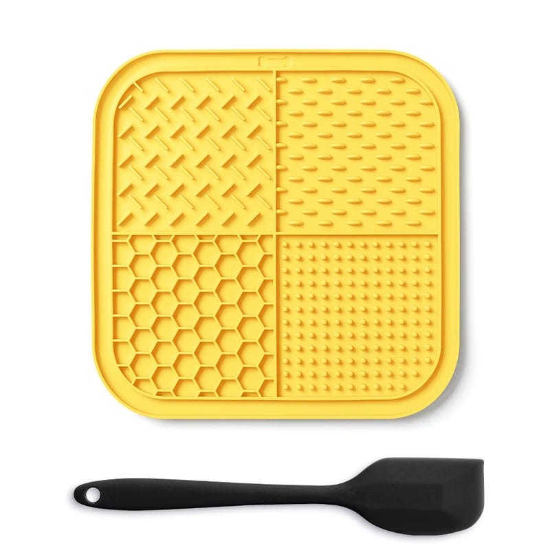 Yellow silicone lick mat for dogs and cats with suction cups and a black spoon