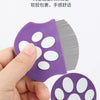 A purple mini pet grooming comb with non-slip pad design and a white paw shape is held by a hand.