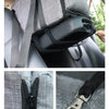 A portable pet car bed featuring a padded headrest and safety strap attached to a gray fabric seat.