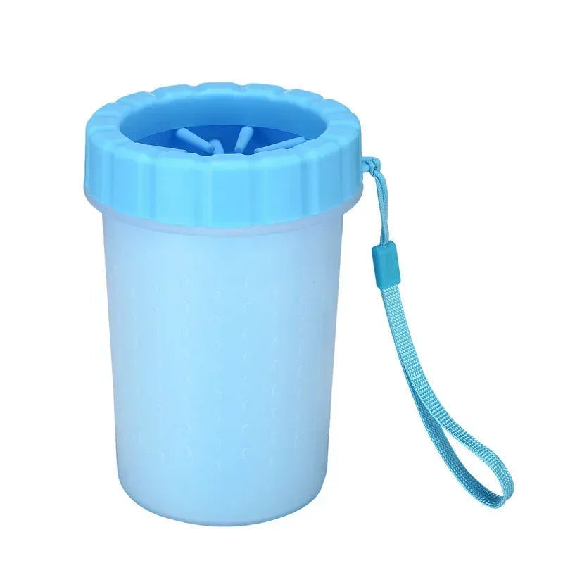 A light blue silicone pet paw cleaner container with a blue silicone brush and a blue cord.