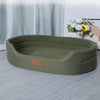 A rectangular olive green washable waterproof dog bed mat lying on a light gray carpet.