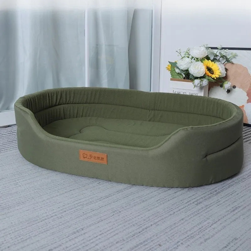 A rectangular olive green washable waterproof dog bed mat lying on a light gray carpet.