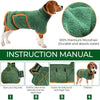 Un chien brun portant un manteau de serviette verte avec des bordures orange.