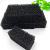Two pieces of black aquarium bio sponge filter media are shown on a white surface.