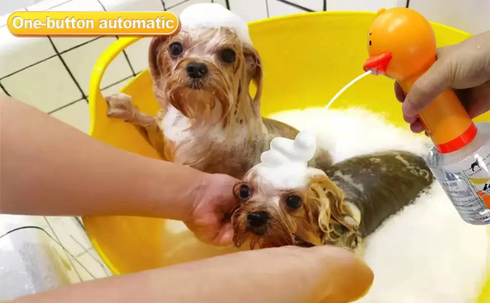 A dog is being bathed with foam dispensed by an orange electric device in a yellow bowl.