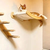 A tabby cat is relaxing in a wooden wall-mounted hammock and climbing shelf system.