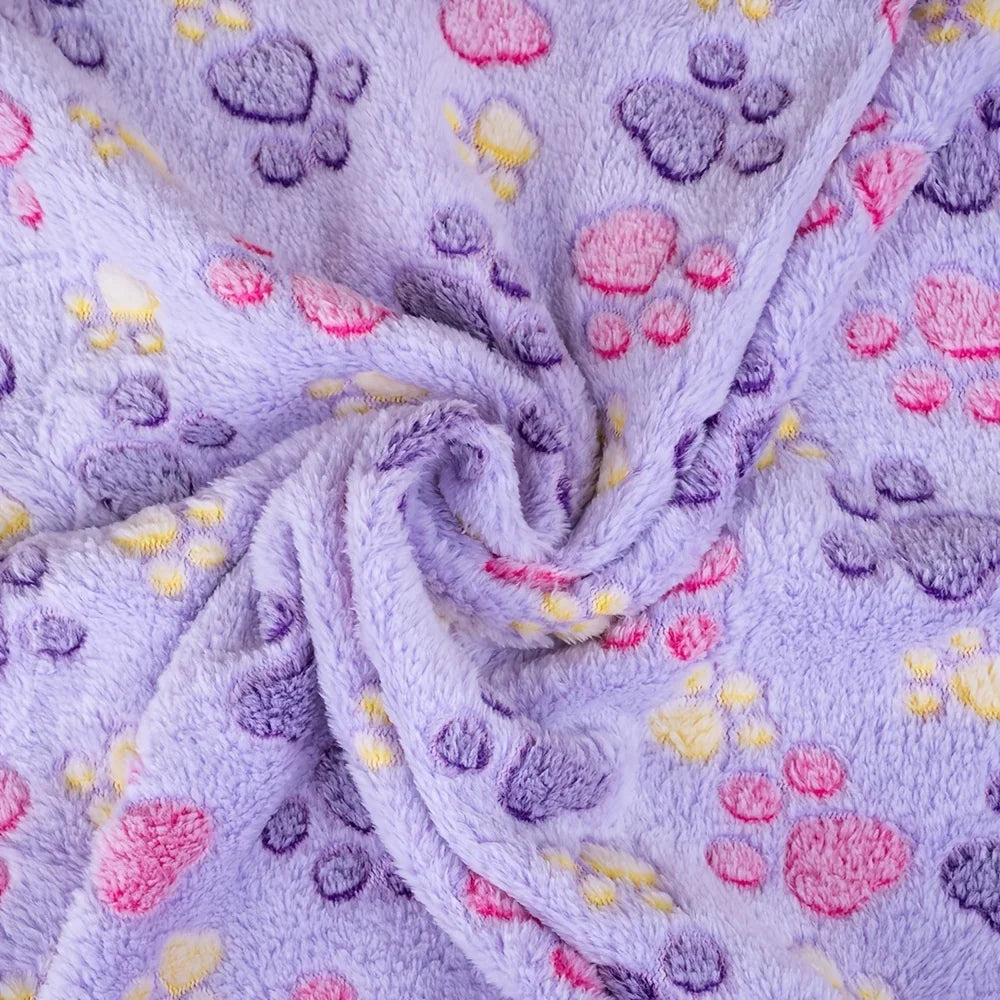 A soft lavender fleece blanket featuring a pattern of purple and pink paw prints.