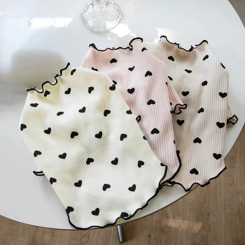 Hellrosa und cremefarbener gestrickter Hund- oder Katzenbody, präsentiert auf weißem Untergrund.