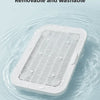 A white dual-layer cat litter mat is shown being flushed and cleaned in water.