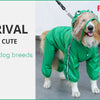 A dog wearing a green harness and waste bag dispenser is shown next to a red dog wearing an orange harness.