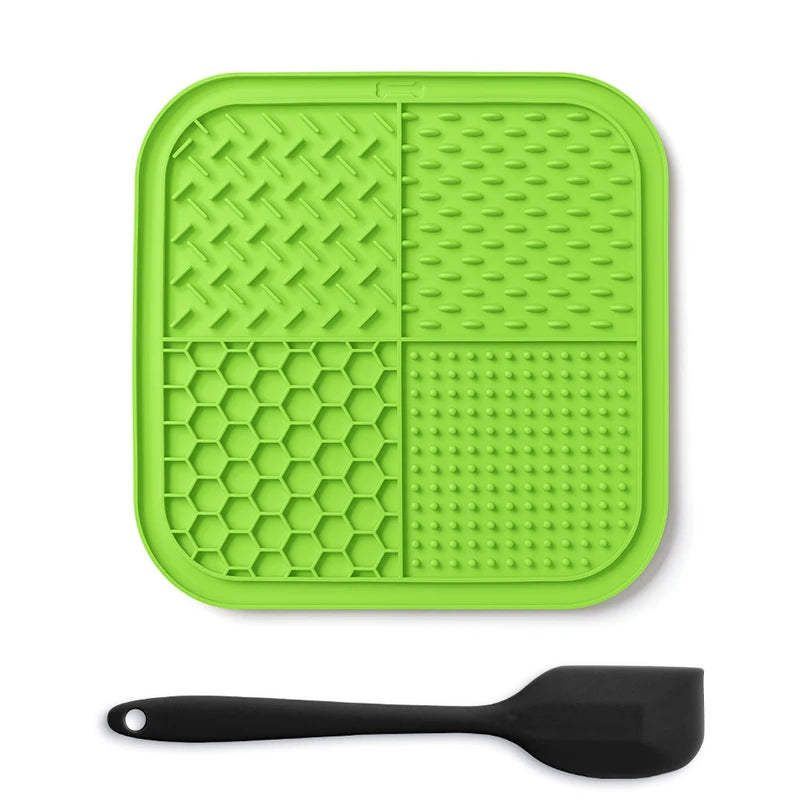A bright green silicone lick mat for pets with suction cups and a black silicone spoon.