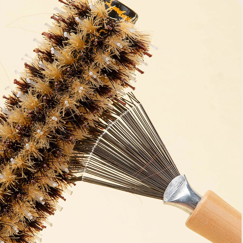 A close-up of a natural wooden hairbrush cleaner with golden bristles and a wooden handle.