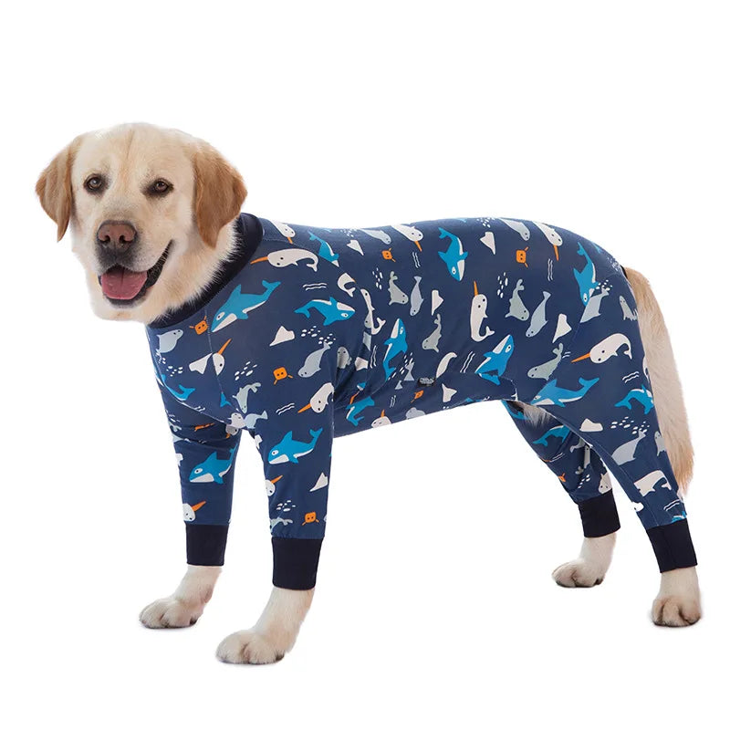 A golden retriever wearing a blue cartoon animal print jumpsuit.