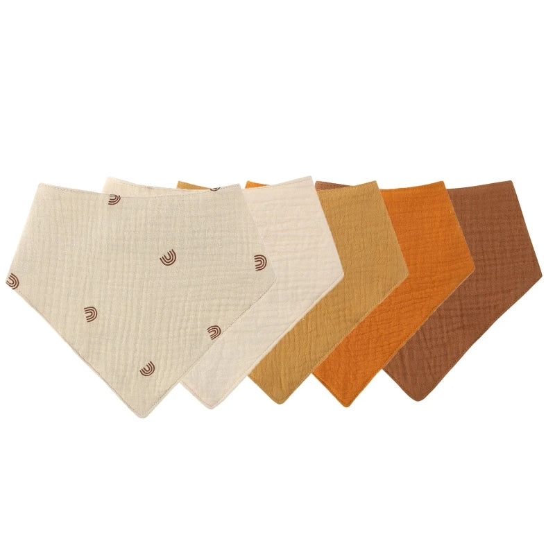 A pack of three soft cotton baby bibs in various earth tones including beige, tan, orange, and brown.