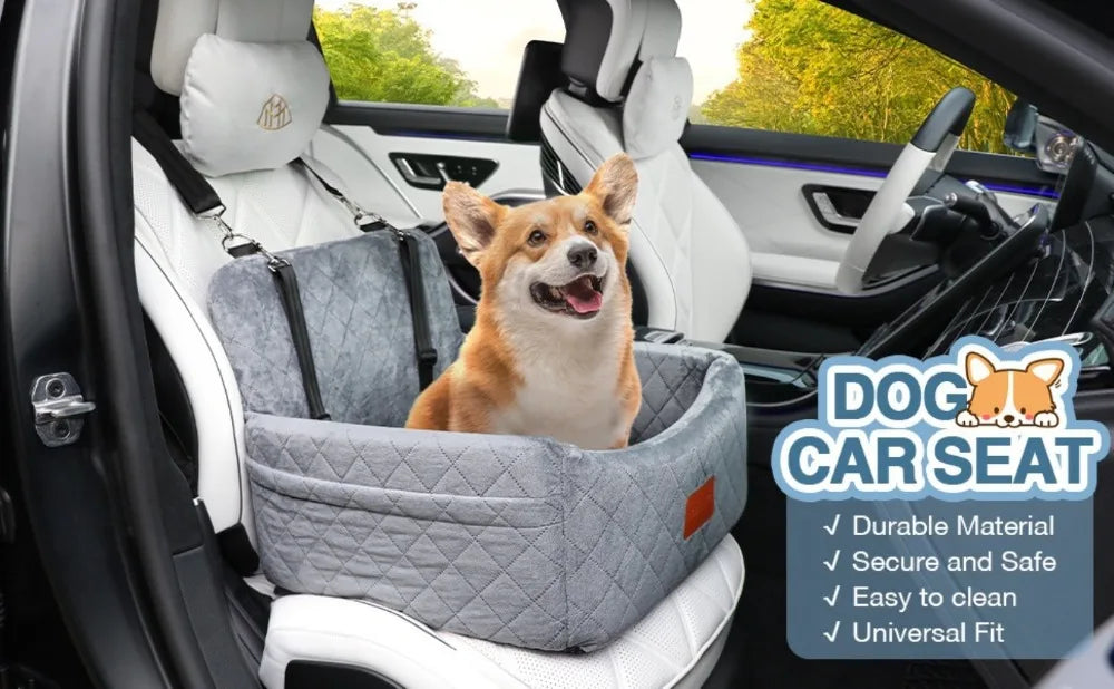 A small dog is sitting inside a gray car seat in a vehicle, demonstrating the features of a dog car seat.