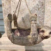 A handcrafted tree hugger bird feeder made of resin resembling a small bird, displayed on a stone surface.