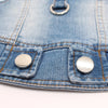 Close-up of a classic blue denim dog jacket showing stitching and silver metal snaps.