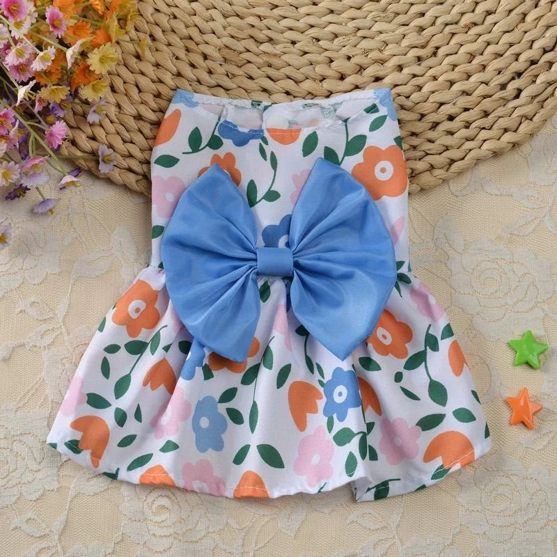 Robe d'été bleu clair et blanc pour chien avec imprimé floral orange et grand nœud bleu.