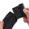 A hand is holding a black biodegradable dog poop bag with an easy-tear design.