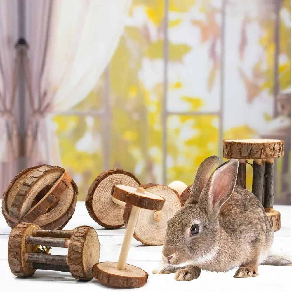 A small rabbit is interacting with natural wooden chew toys and blocks.