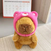 A fluffy brown capybara plush doll wearing a pink hoodie with small wings.