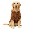 Ein goldener Retriever trägt einen braunen flauschigen Fleece-Wintermantel und sitzt auf weißem Hintergrund.
