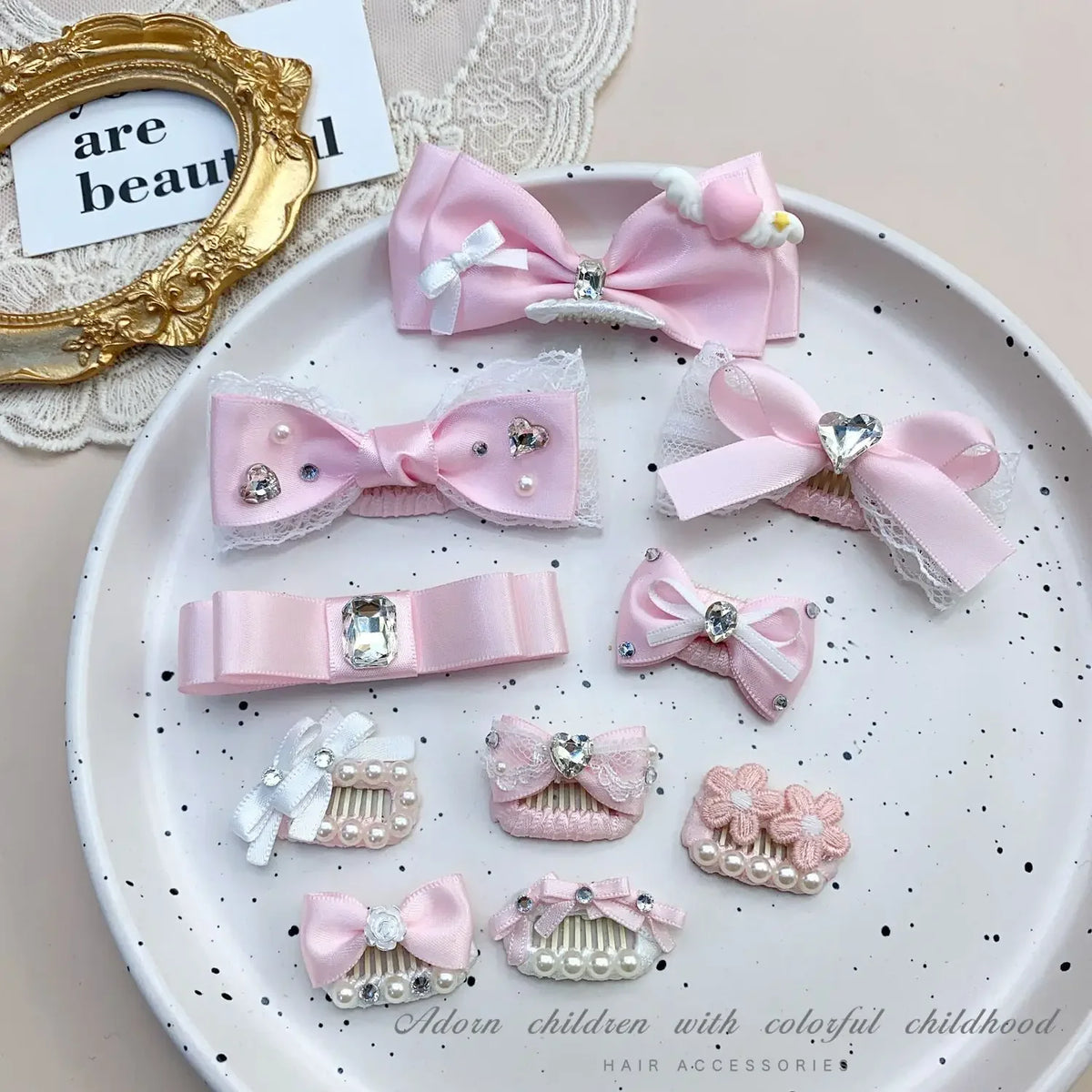 Pink bow hair accessory featuring pearl and rhinestone accents for children's hair.