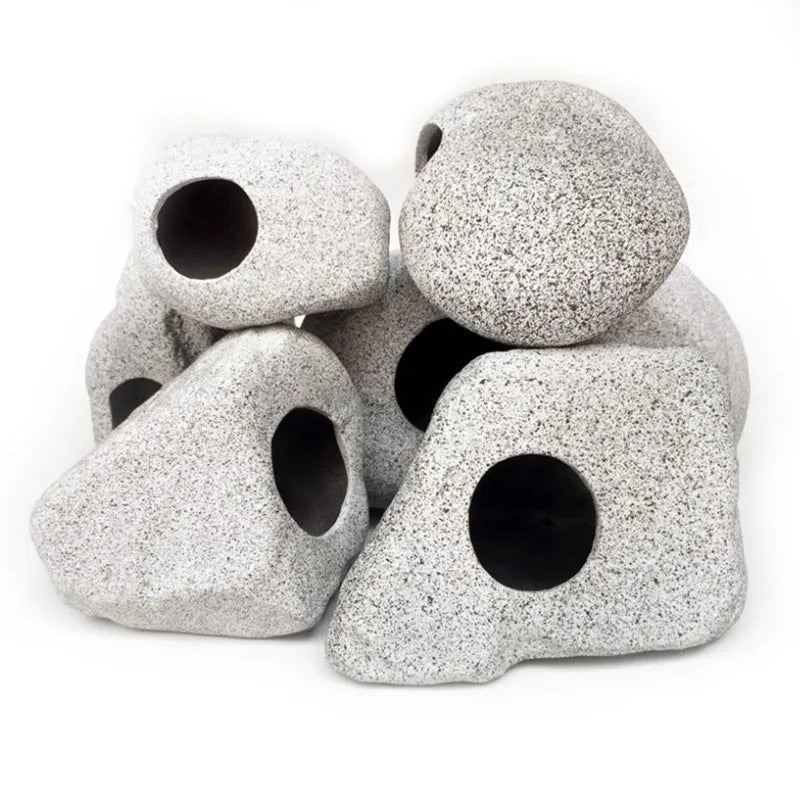 A collection of rough, gray ceramic pieces shaped like cichlid caves for aquarium decor.