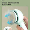 A hand is using a light-pressure comb to brush pet fur from the scalp, demonstrating a new-level grooming tool.