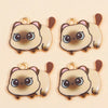 Three gold-ringed cat pendant charms in a beige and brown color palette.