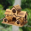 Handmade wooden bird house with a pitched roof and entrance holes, made of natural wood.