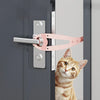 A pink adjustable pet door stopper is installed on a gray door, with a tabby cat looking at the camera.