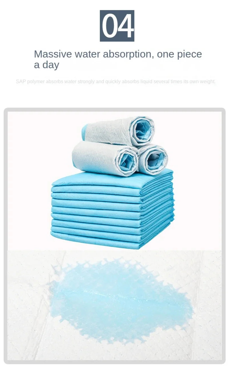 Ein Stapel hellblauer saugfähiger Pads und ein verschütteter Flüssigkeitspuddle auf einer weißen Oberfläche.