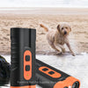 An intelligent ultrasonic wave dog training device with an orange body and a black component, shown next to a dog.