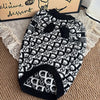 Black and white patterned luxury knit sweater for dogs displayed on a wooden surface.