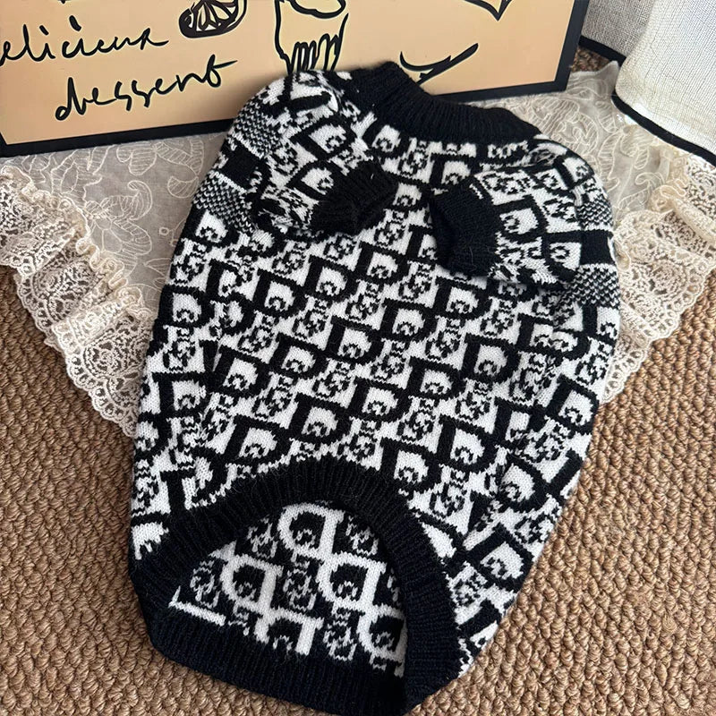 Black and white patterned luxury knit sweater for dogs displayed on a wooden surface.