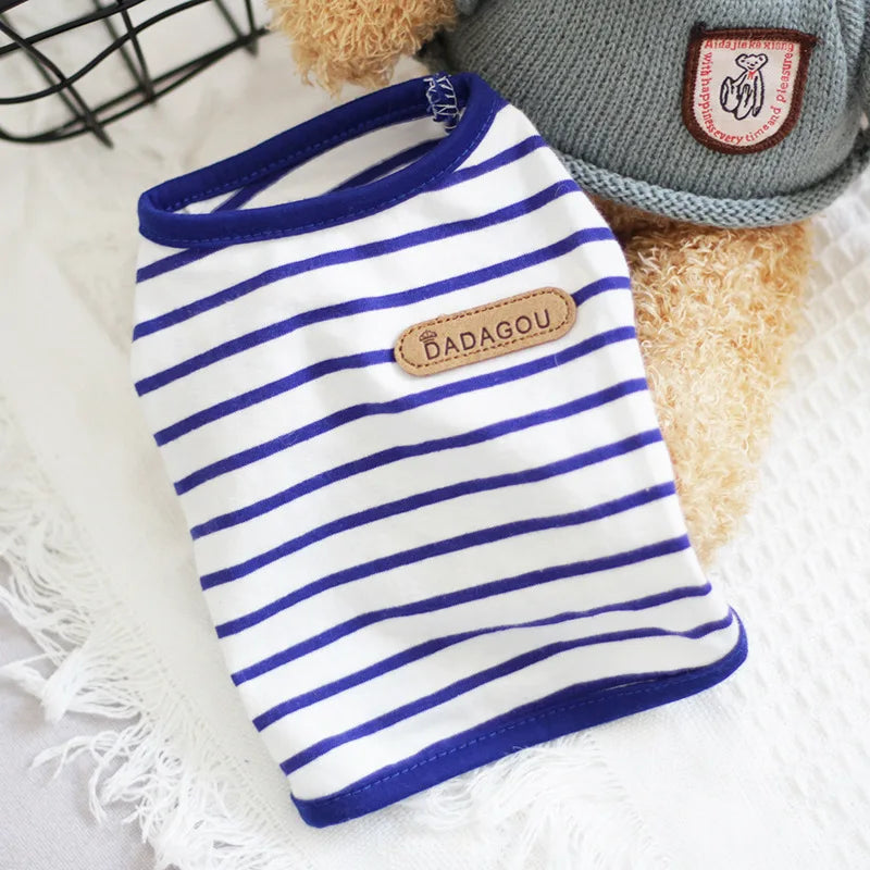 A white and blue striped sleeveless vest for a small dog or cat resting on a white surface.