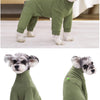 Un perro gris peludo vistiendo un traje de mono de forro polar verde oliva.