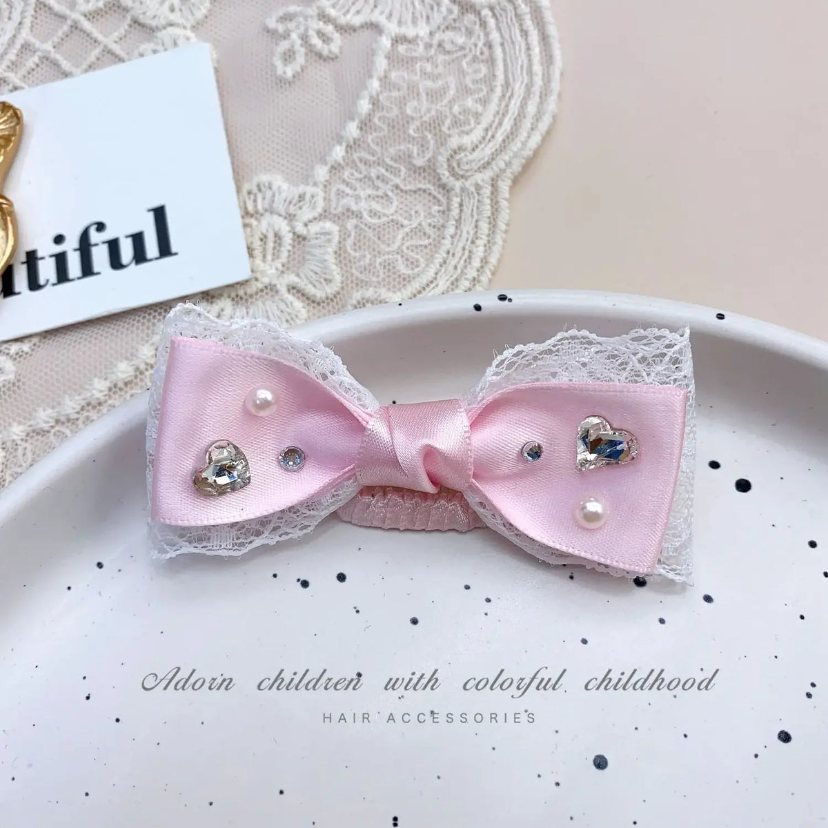 Pink bow hair accessory with white lace and rhinestone pearl accents