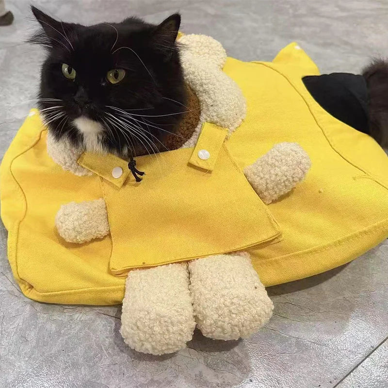 A yellow breathable mesh pet carrier backpack with white fluffy padding, featuring a black cat peering out.